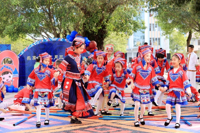 圖4：4月9日，在廣西柳州市融安縣實驗小學校園，一名老師帶著學生跳竹竿舞。（譚凱興 攝）.JPG